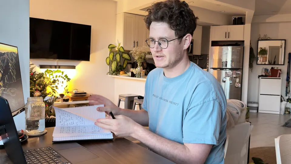 Luke Alley reviews his notebook during an online health coaching call at home.
